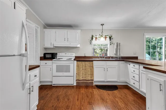 a kitchen with granite countertop white cabinets and white appliances