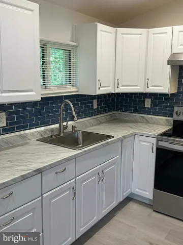 a kitchen with a stove and white cabinets