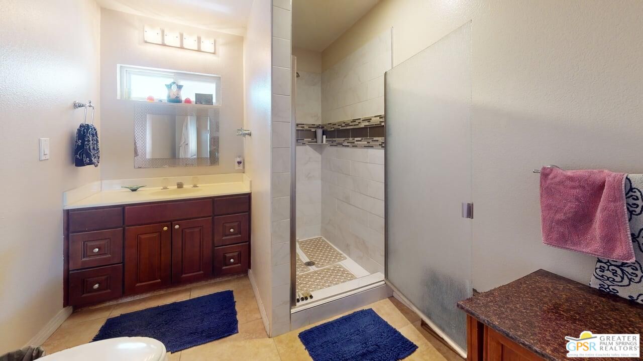 14701 Old Morongo Road Whitewater, CA 92282 - Photo 46 of 70 a bathroom with a granite countertop sink a mirror and shower