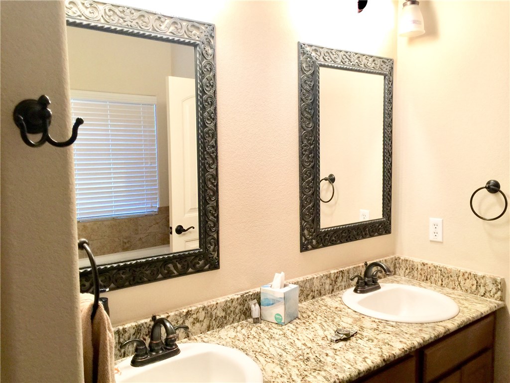 10052 Janet Loop Dripping Springs, TX 78620 - Photo 16 of 26 Master Bathroom with Framed Mirrors, Double Vanity and Granite Counters