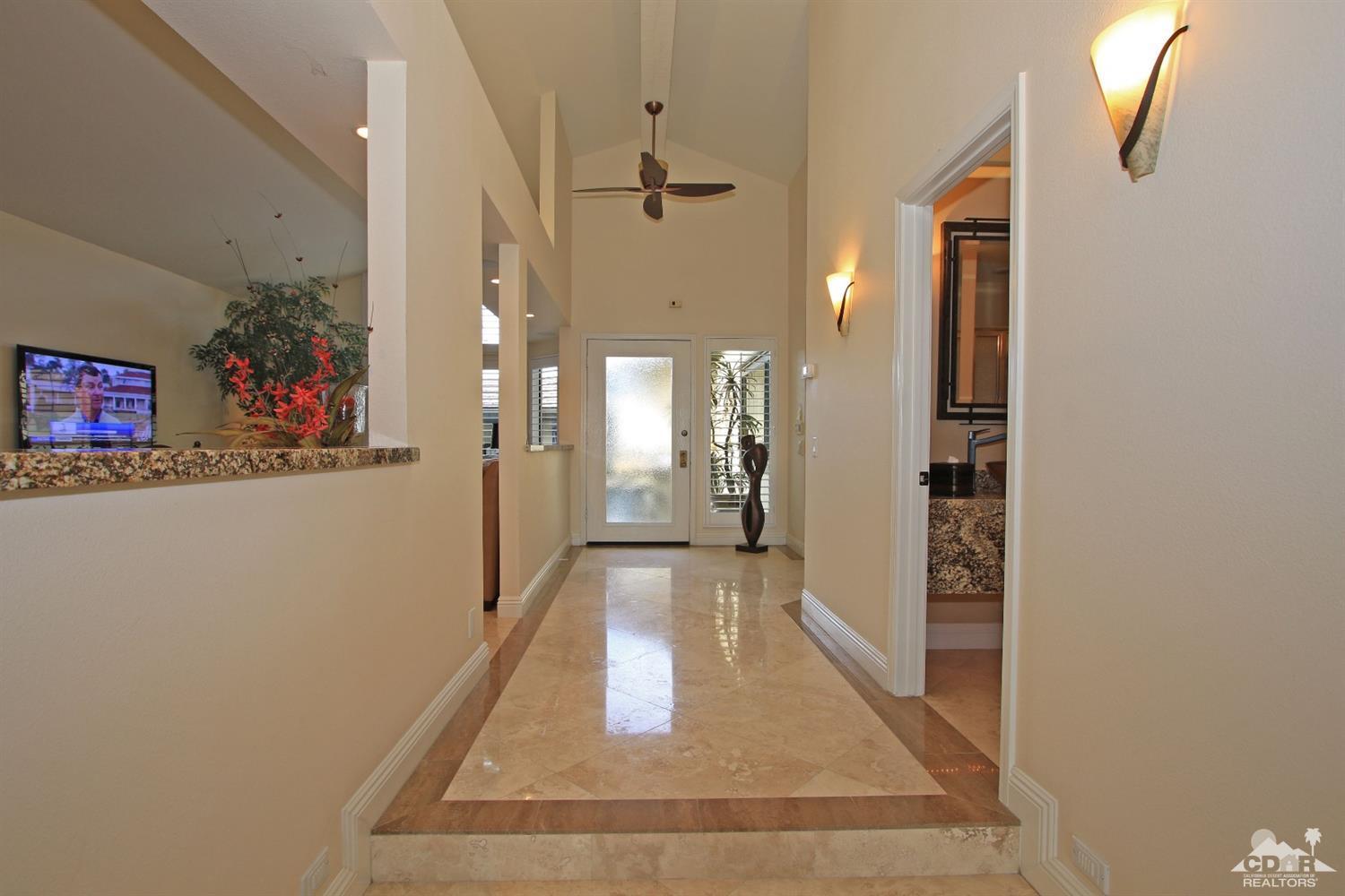 326 Red River Road Palm Desert, CA 92211 - Photo 30 of 54 a view of a hallway with a dining table and chairs