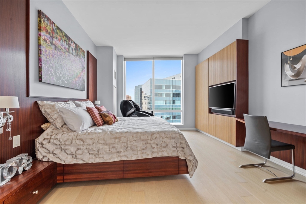 1 Franklin Street, Unit 3808 Boston, MA 02110 - Photo 14 of 40 a bedroom with a large bed and a flat tv screen on dresser