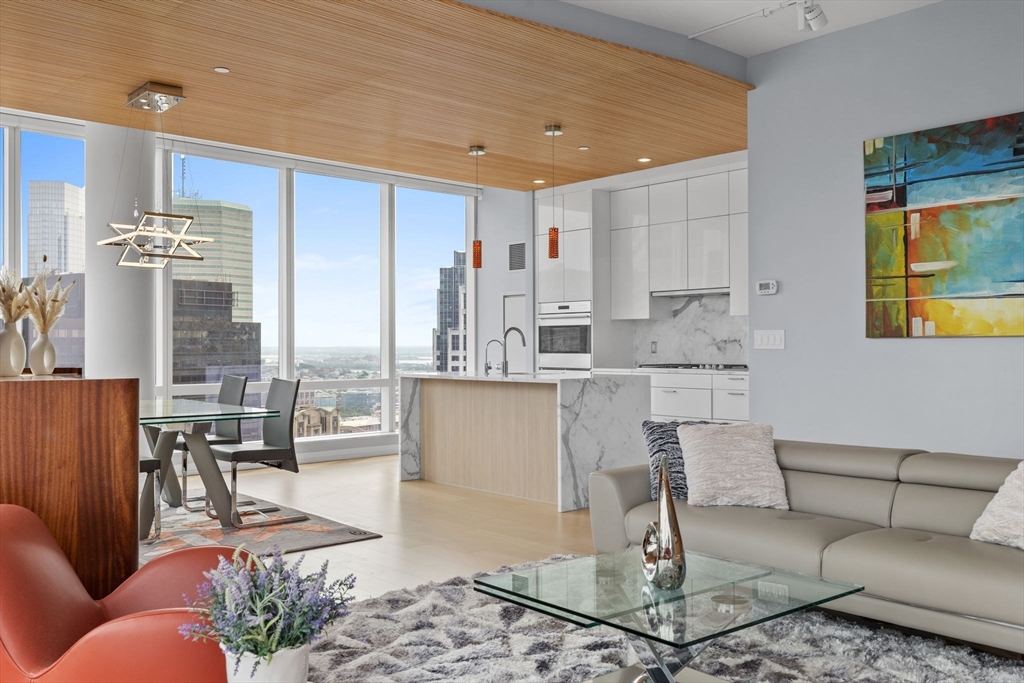 1 Franklin Street, Unit 3808 Boston, MA 02110 - Photo 5 of 40 a living room with kitchen view and a dining table with kitchen view