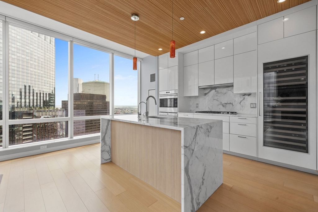 1 Franklin Street, Unit 3808 Boston, MA 02110 - Photo 9 of 40 a kitchen with stainless steel appliances granite countertop a stove a sink and a microwave