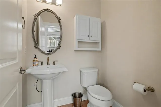 a bathroom with a toilet a sink and mirror