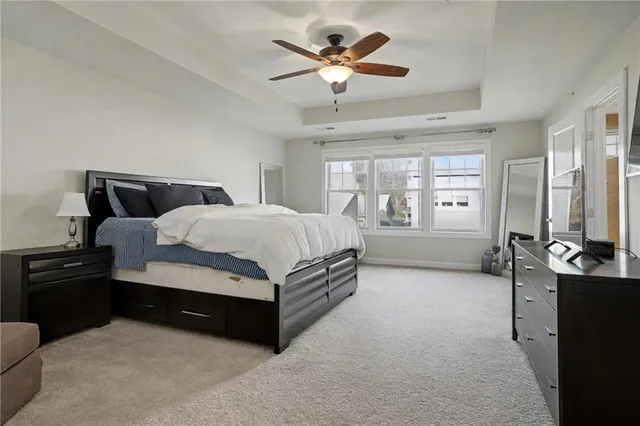 a spacious bedroom with a bed and a ceiling fan