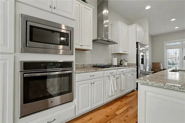 a kitchen with granite countertop white cabinets stainless steel appliances and sink