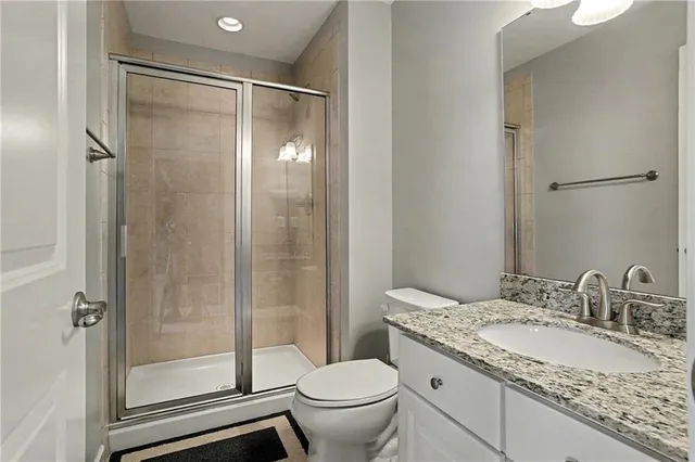 a bathroom with a granite countertop sink toilet and shower