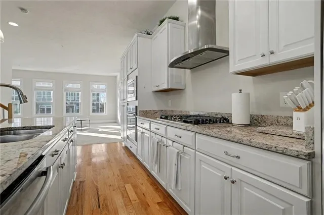 a kitchen with granite countertop a sink a stove and cabinets