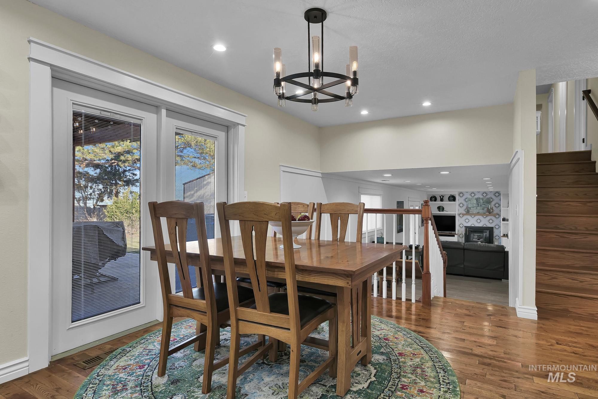 315 East Pat Lane Caldwell, ID 83607 - Photo 11 of 50 Dining room with stairway access to the walk out basement, hardwood finished floors, recessed lighting, and a chandelier