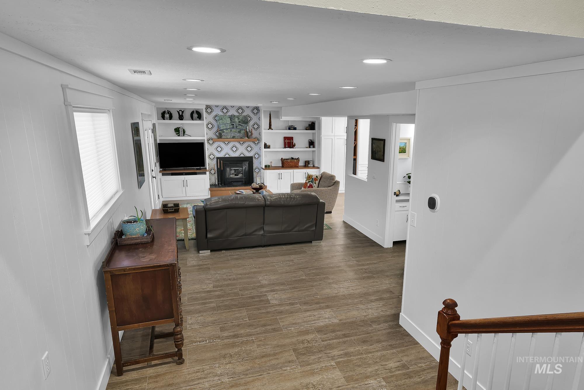 315 East Pat Lane Caldwell, ID 83607 - Photo 17 of 50 Living area featuring a glass covered fireplace, light wood-style floors, and built in shelves