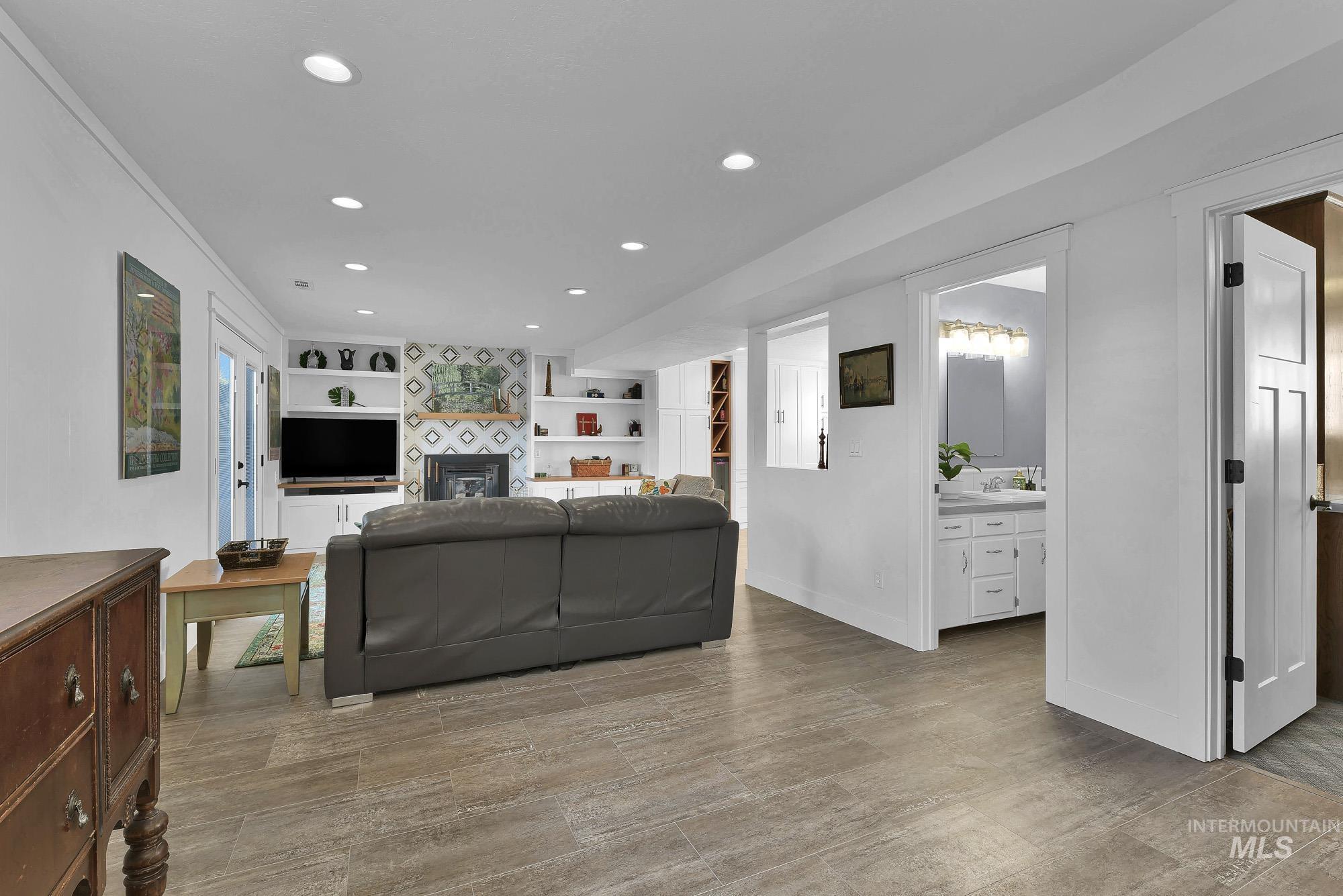 315 East Pat Lane Caldwell, ID 83607 - Photo 19 of 50 Family room featuring recessed lighting, built in features, light wood-like LVP flooring, and a tiled fireplace area with pellet stove insert