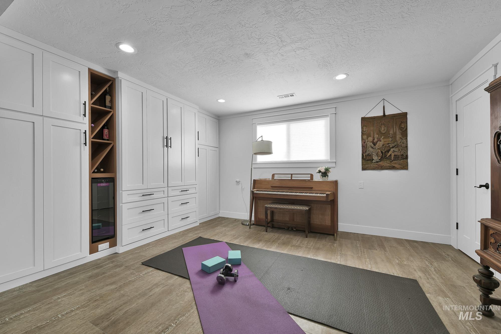 315 East Pat Lane Caldwell, ID 83607 - Photo 23 of 50 Family Room - Exercise room featuring light wood-like LVP flooring, built in storage, a textured ceiling, and recessed lighting