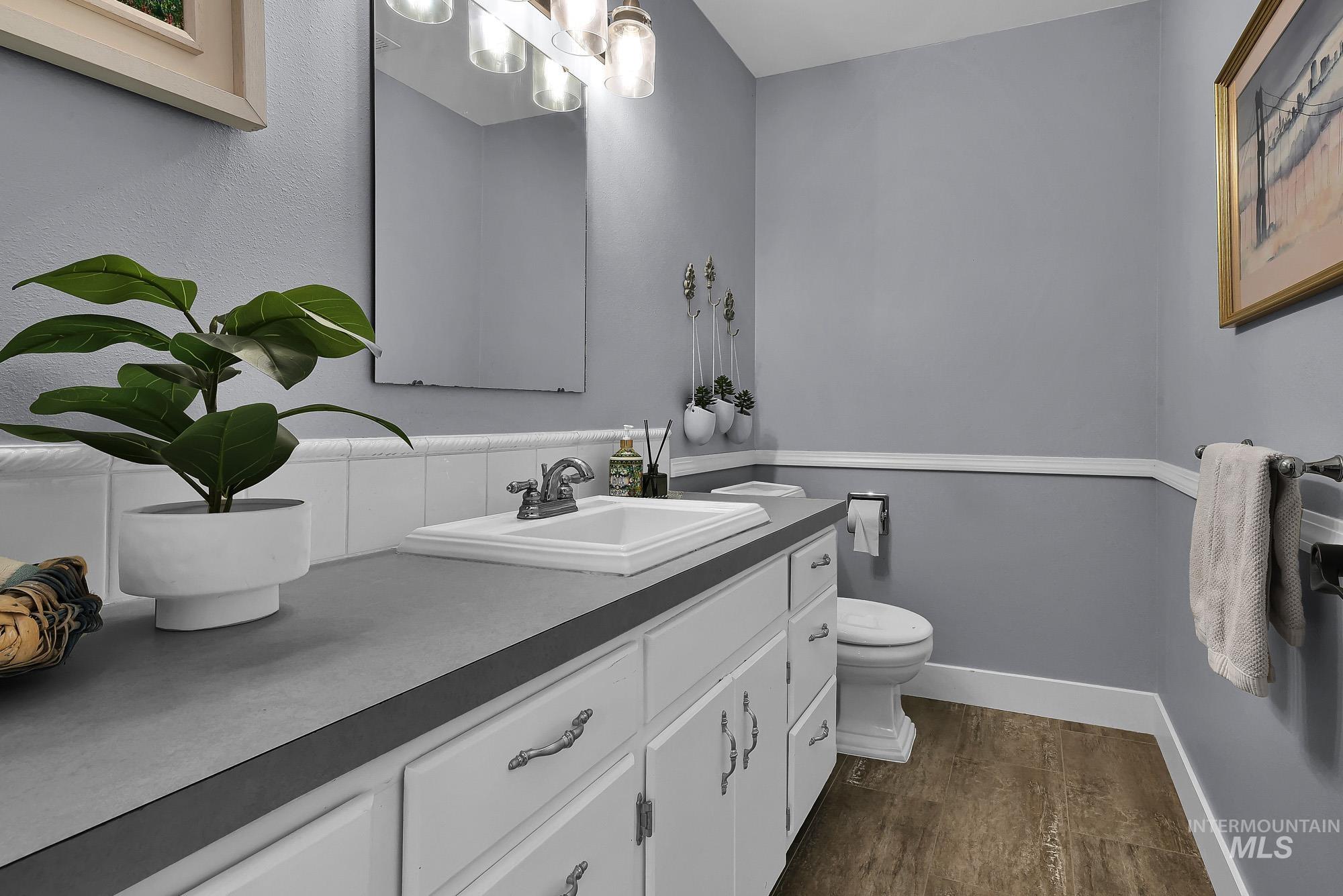 315 East Pat Lane Caldwell, ID 83607 - Photo 24 of 50 Half bath with vanity, dark wood-like finished LVP floors, and new lighting