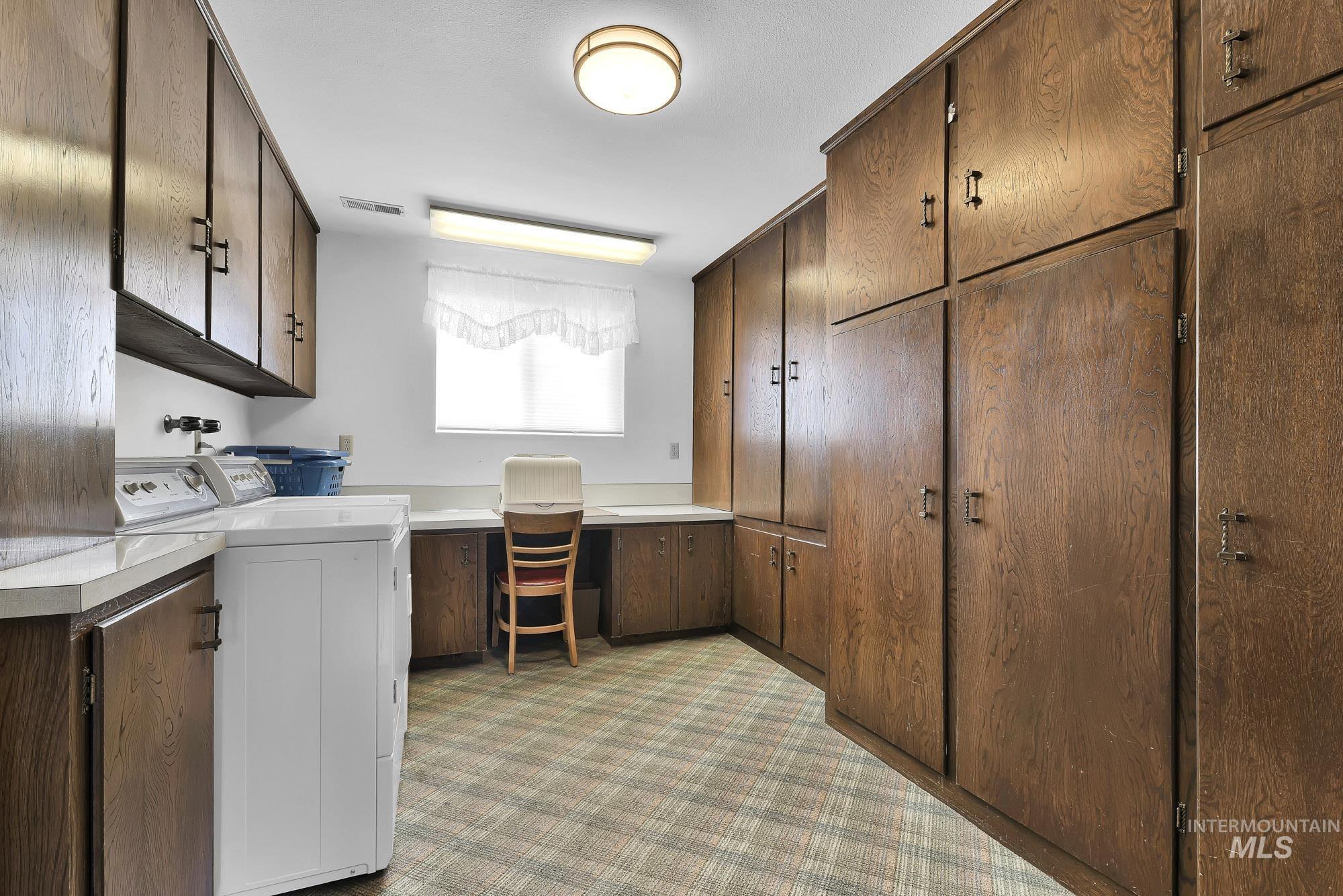 315 East Pat Lane Caldwell, ID 83607 - Photo 25 of 50 Laundry area featuring multiple built in cabinets, a desk with craft area, washer and dryer