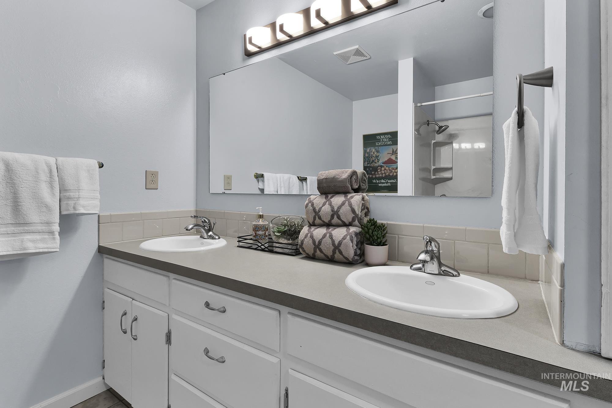 315 East Pat Lane Caldwell, ID 83607 - Photo 30 of 50 Full bath with double vanities, a tub/shower combo, and tile floors