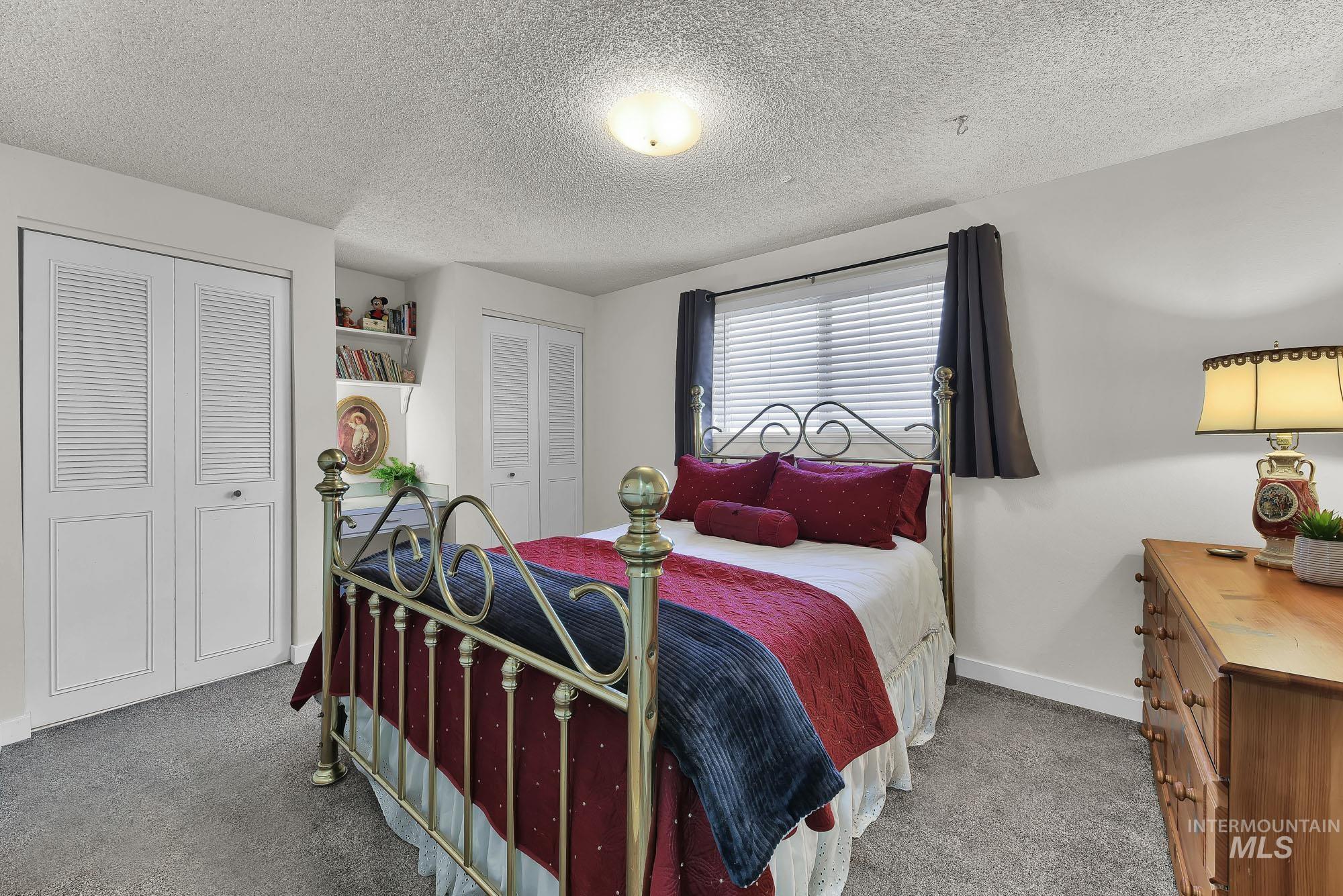 315 East Pat Lane Caldwell, ID 83607 - Photo 31 of 50 Bedroom featuring two closets, light carpet, and a built in desk area