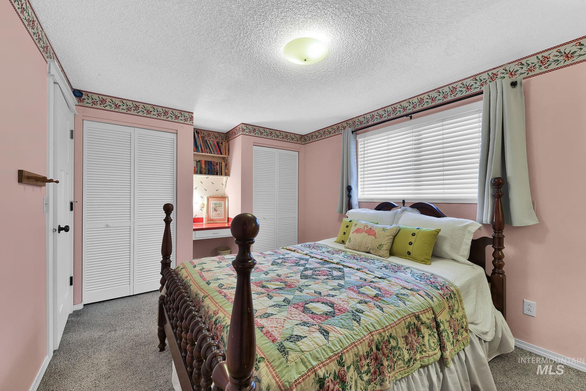 315 East Pat Lane Caldwell, ID 83607 - Photo 33 of 50 Carpeted bedroom featuring multiple closets and a built in desk area with shelving above