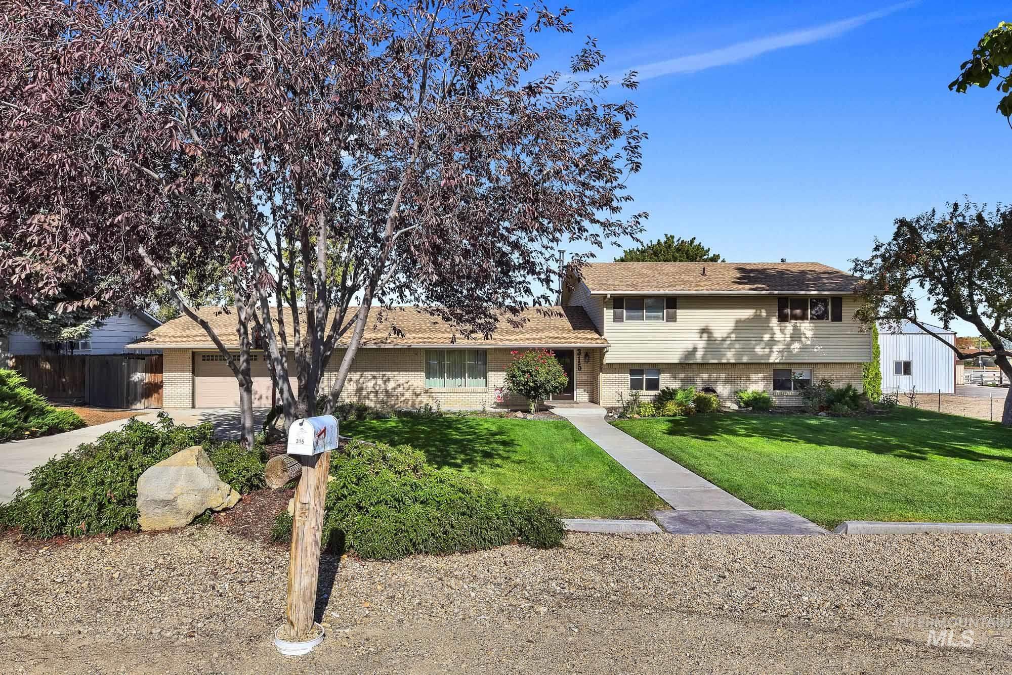 315 East Pat Lane Caldwell, ID 83607 - Photo 4 of 50 Try-level home featuring brick accented front and vinyl siding with a 2 car garage