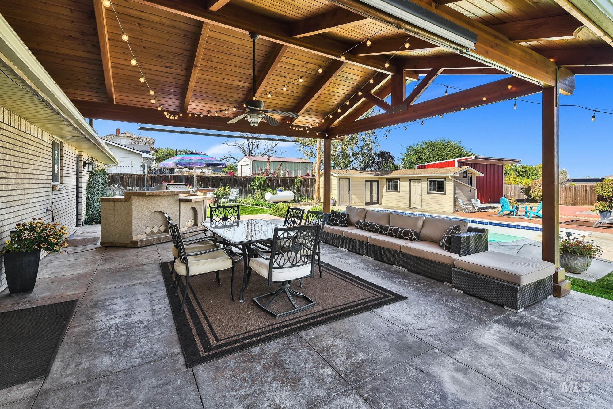 315 East Pat Lane Caldwell, ID 83607 - Photo 42 of 50 Fenced backyard with a patio area, an outdoor hangout area, an outdoor pool building, outdoor dining area, and a ceiling fan