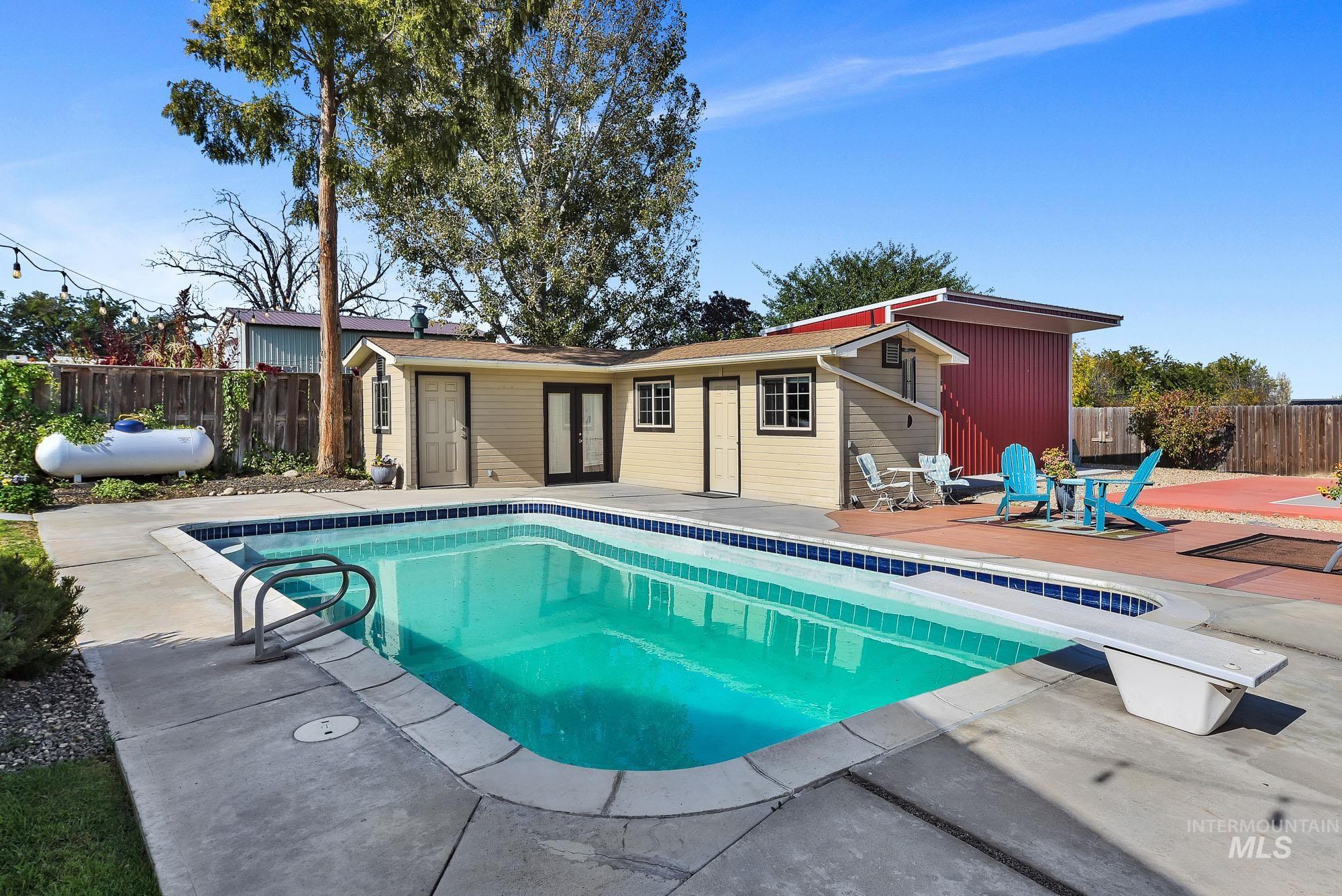 315 East Pat Lane Caldwell, ID 83607 - Photo 46 of 50 View of pool featuring a patio area - a diving board and the back drop of the pool house