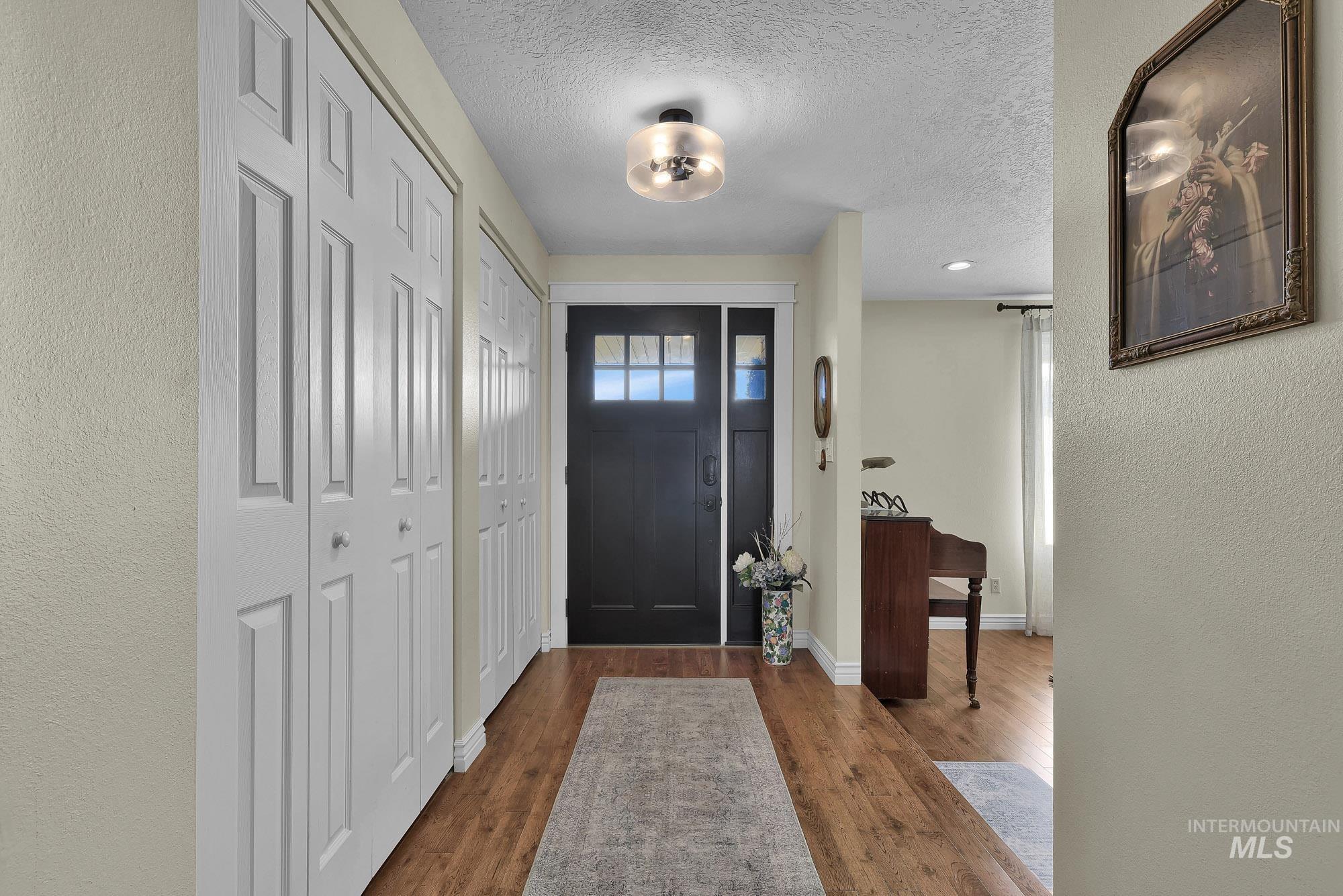 315 East Pat Lane Caldwell, ID 83607 - Photo 6 of 50 Foyer featuring a textured wall, a textured ceiling, and deep hardwood flooring