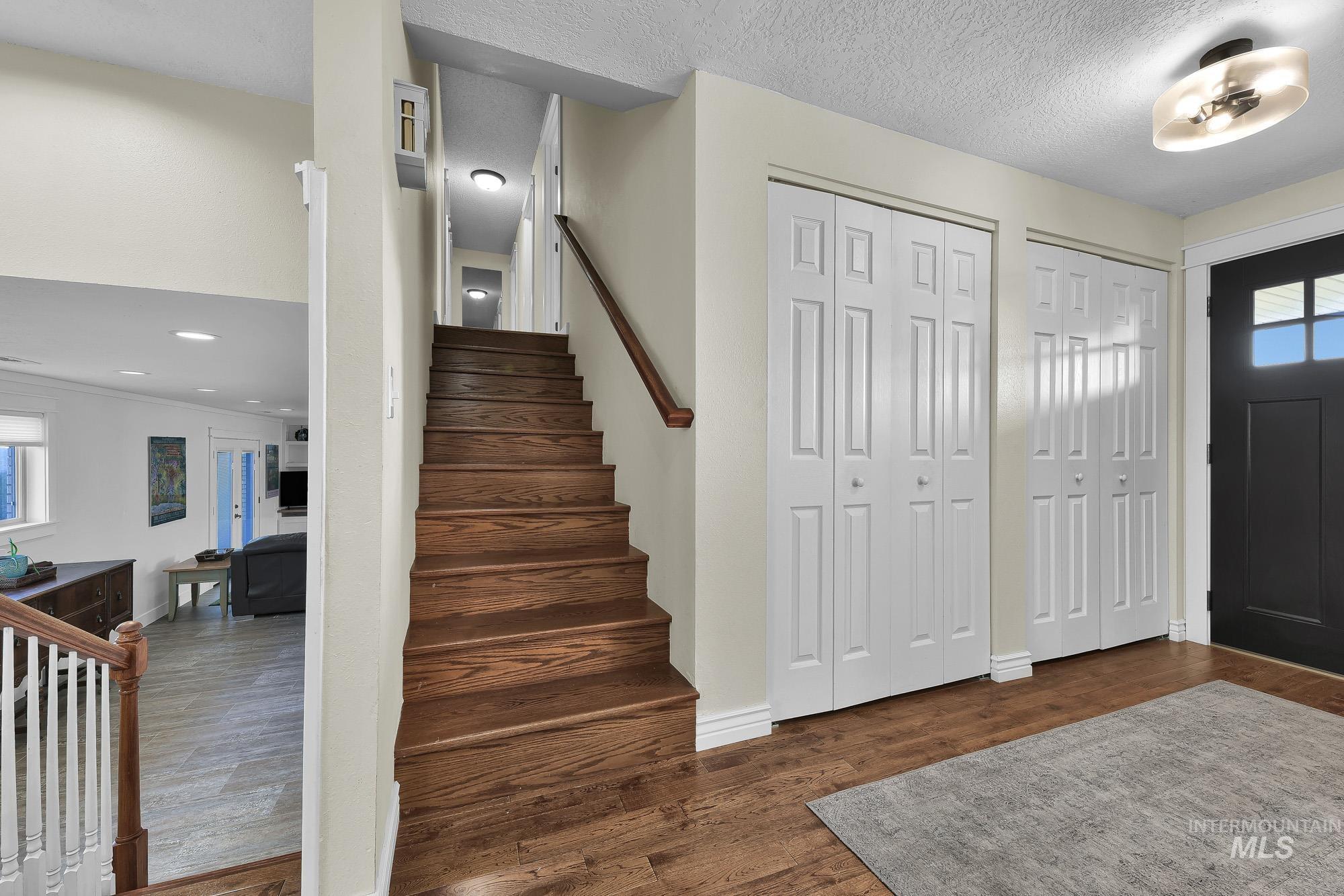 315 East Pat Lane Caldwell, ID 83607 - Photo 9 of 50 Entrance foyer with stairway to upper bedrooms, hard wood floors, and a textured ceiling