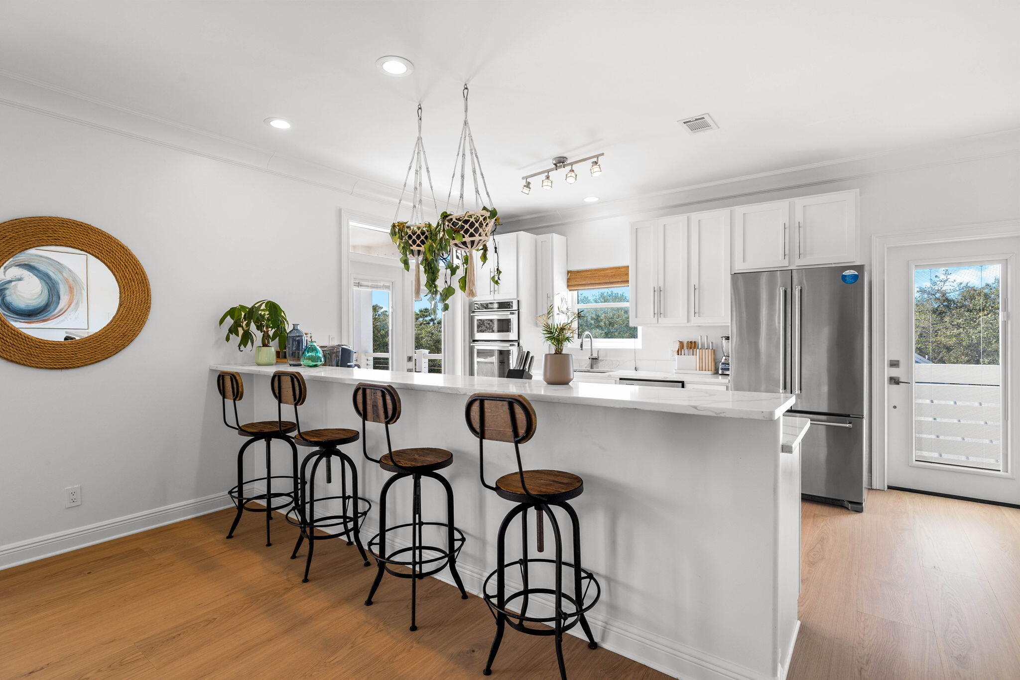 204 Sandstone Street Santa Rosa Beach, FL 32459 - Photo 29 of 80 a kitchen with stainless steel appliances kitchen island granite countertop a dining table chairs and a refrigerator