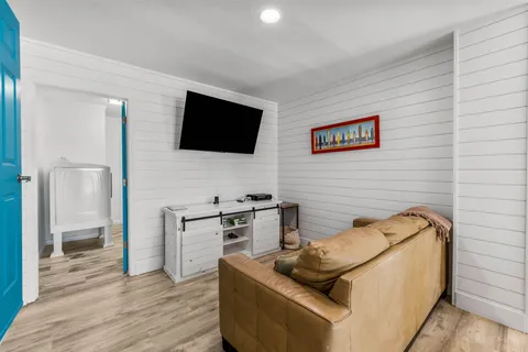 a bedroom with a bed a flat screen tv and a window