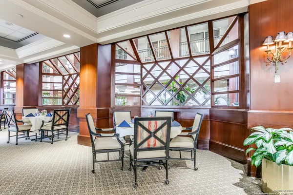 a dining room with furniture and a floor to ceiling window