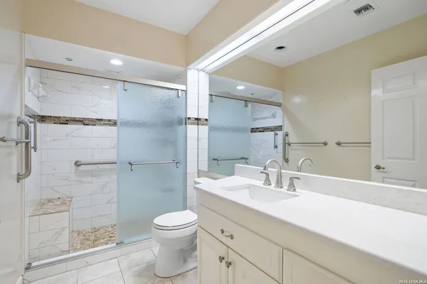 a bathroom with a sink a toilet and shower