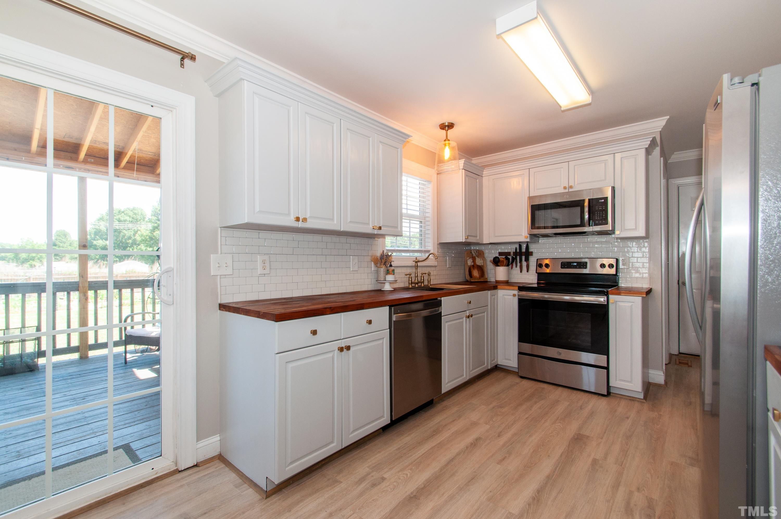 4805 Kure Road Raleigh, NC 27603 - Photo 8 of 31 a kitchen with granite countertop a refrigerator and a stove top oven