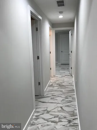 a view of a hallway with wooden floor and closet