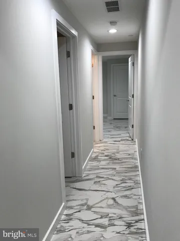 a view of a hallway with wooden floor and closet