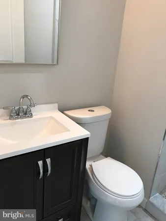 a bathroom with a sink a toilet and a mirror