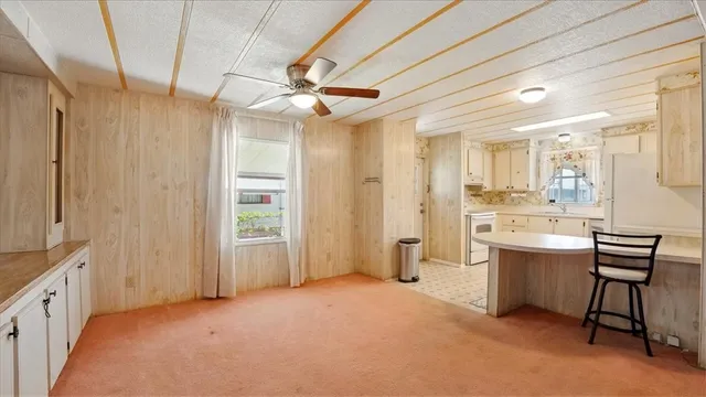 a living room with white furniture and a chandelier