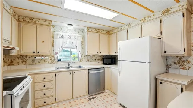 a kitchen with stainless steel appliances white cabinets and a sink