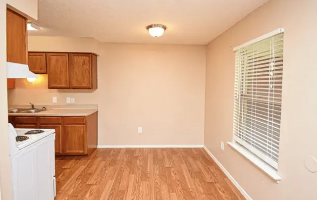 a view of a kitchen with wooden floor and a sink