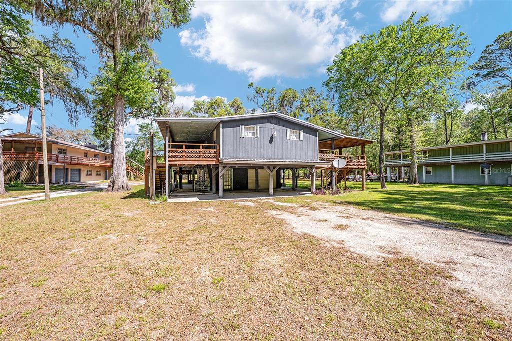 7870 Southwest 25th Place Bell, FL 32619 - Photo 31 of 93 a view of a house with a big yard and large trees