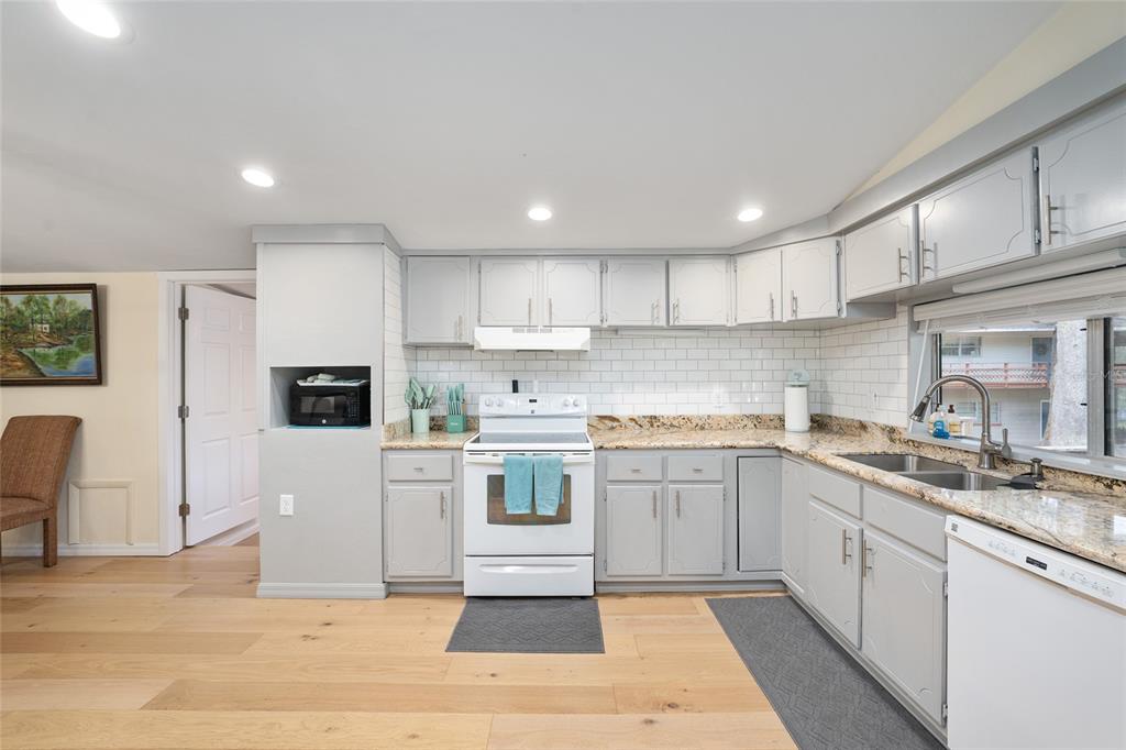 7870 Southwest 25th Place Bell, FL 32619 - Photo 71 of 93 a kitchen with granite countertop a sink a stove a refrigerator cabinets and a dining table