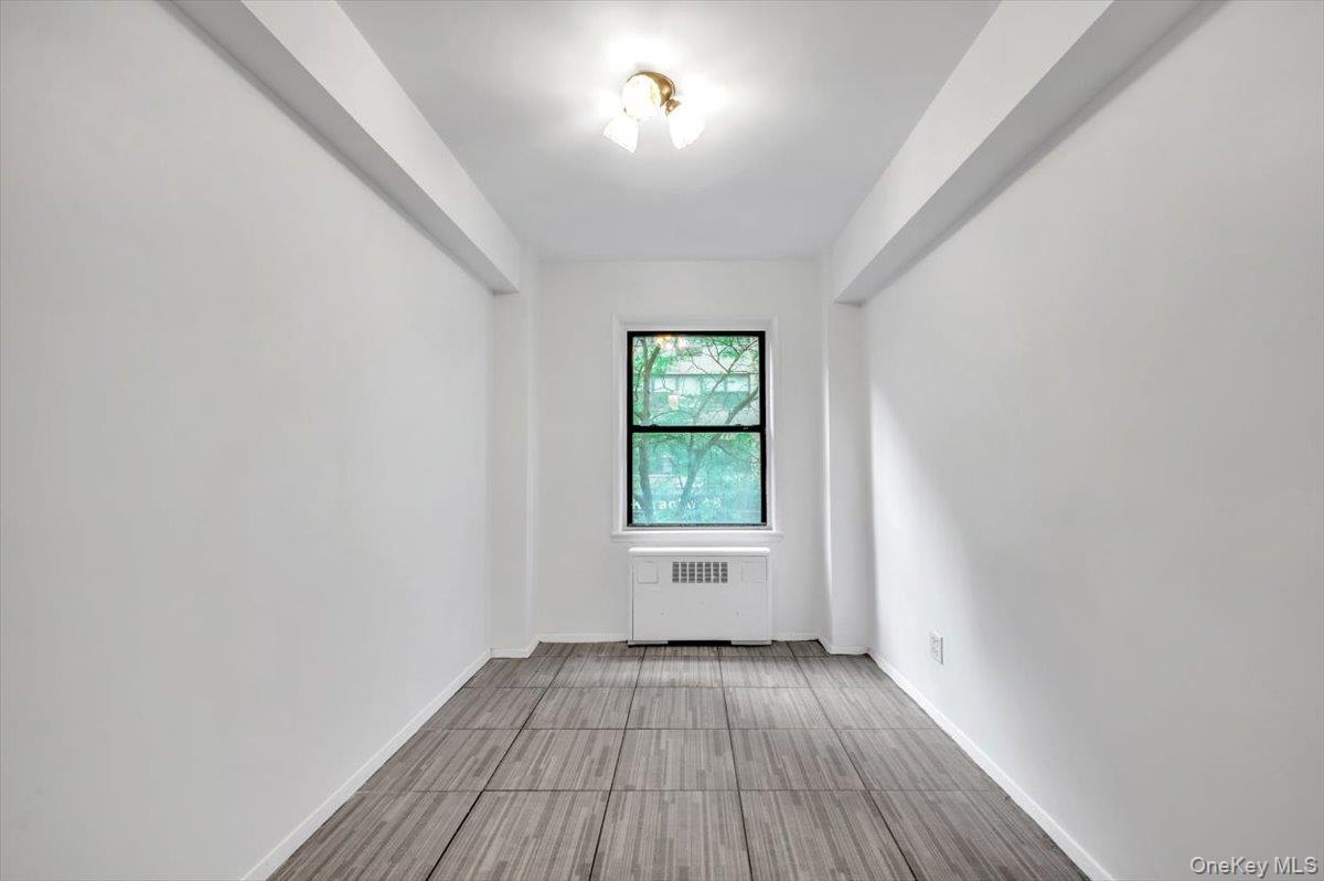 301 East 48th Street, Unit 2C Manhattan, NY 10017 - Photo 12 of 22 an empty room with wooden floor and windows