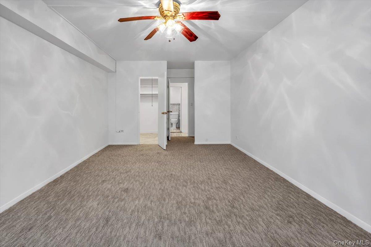 301 East 48th Street, Unit 2C Manhattan, NY 10017 - Photo 16 of 22 wooden floor in an empty room with a chandelier fan