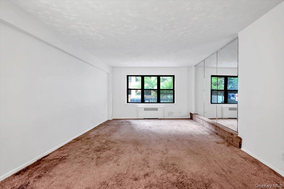 301 East 48th Street, Unit 2C Manhattan, NY 10017 - Photo 2 of 22 an empty room with windows