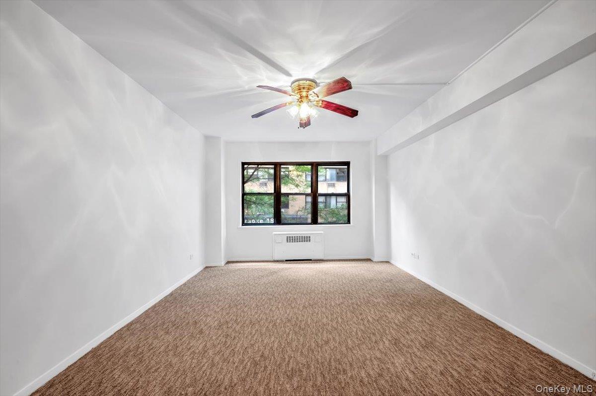 301 East 48th Street, Unit 2C Manhattan, NY 10017 - Photo 7 of 22 a view of an empty room with window and a kitchen