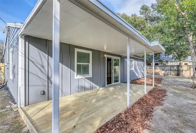 a view of a patio with table and chairs and wooden fence