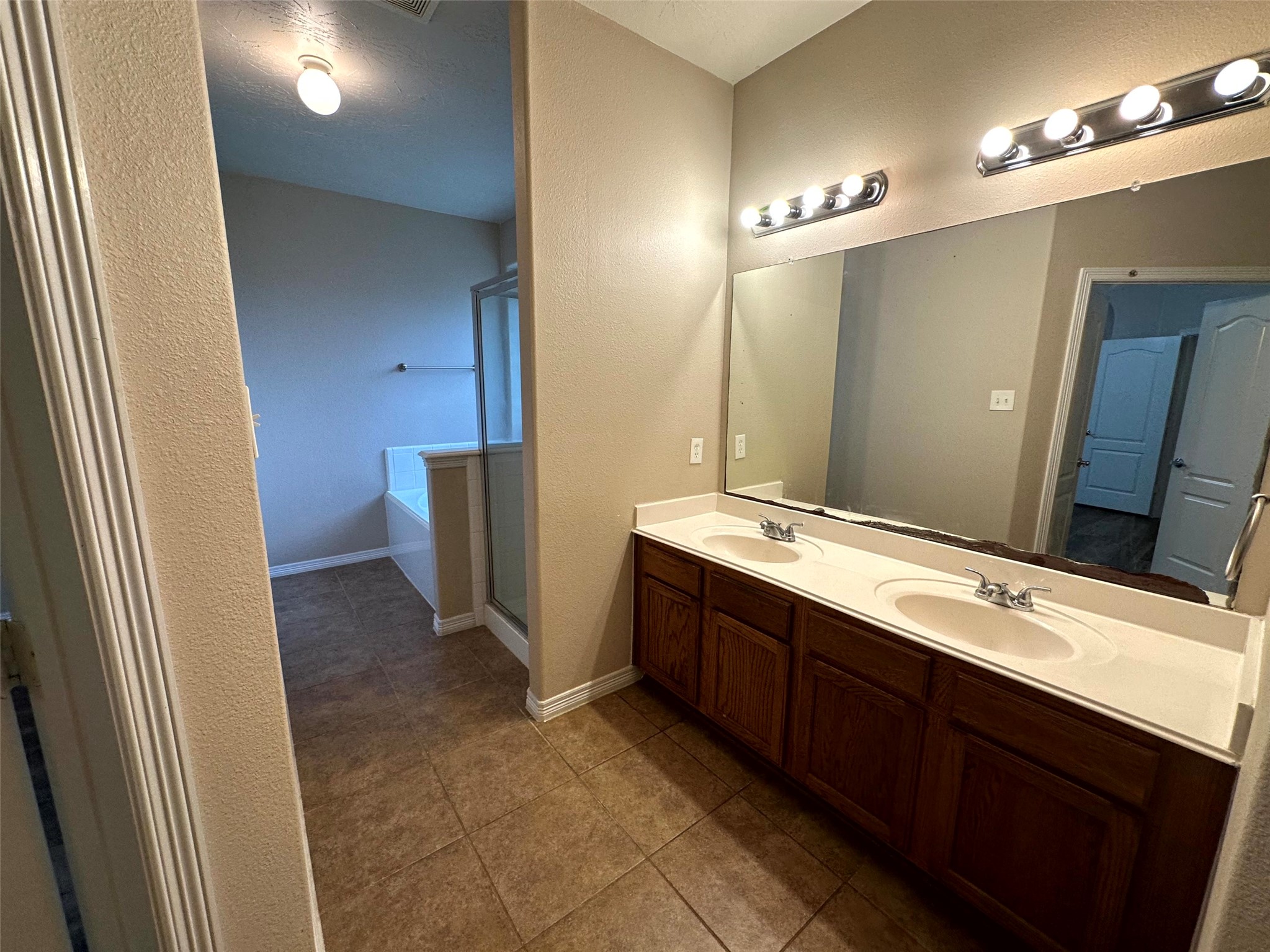 2047 Lulach Lane Conroe, TX 77301 - Photo 17 of 20 a bathroom with a double vanity sink a large mirror and a shower