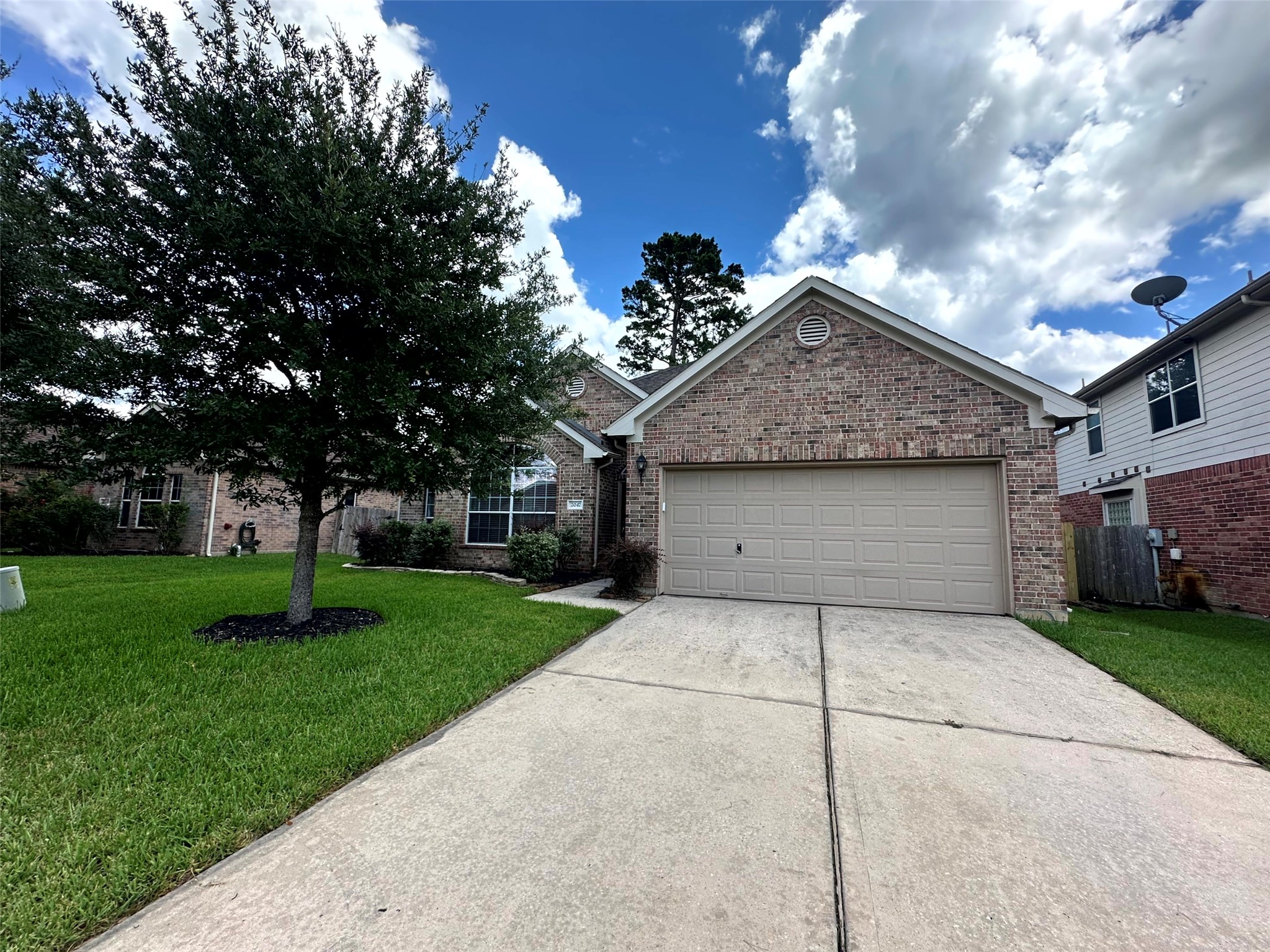 2047 Lulach Lane Conroe, TX 77301 - Photo 20 of 20 a front view of a house with a garden and trees