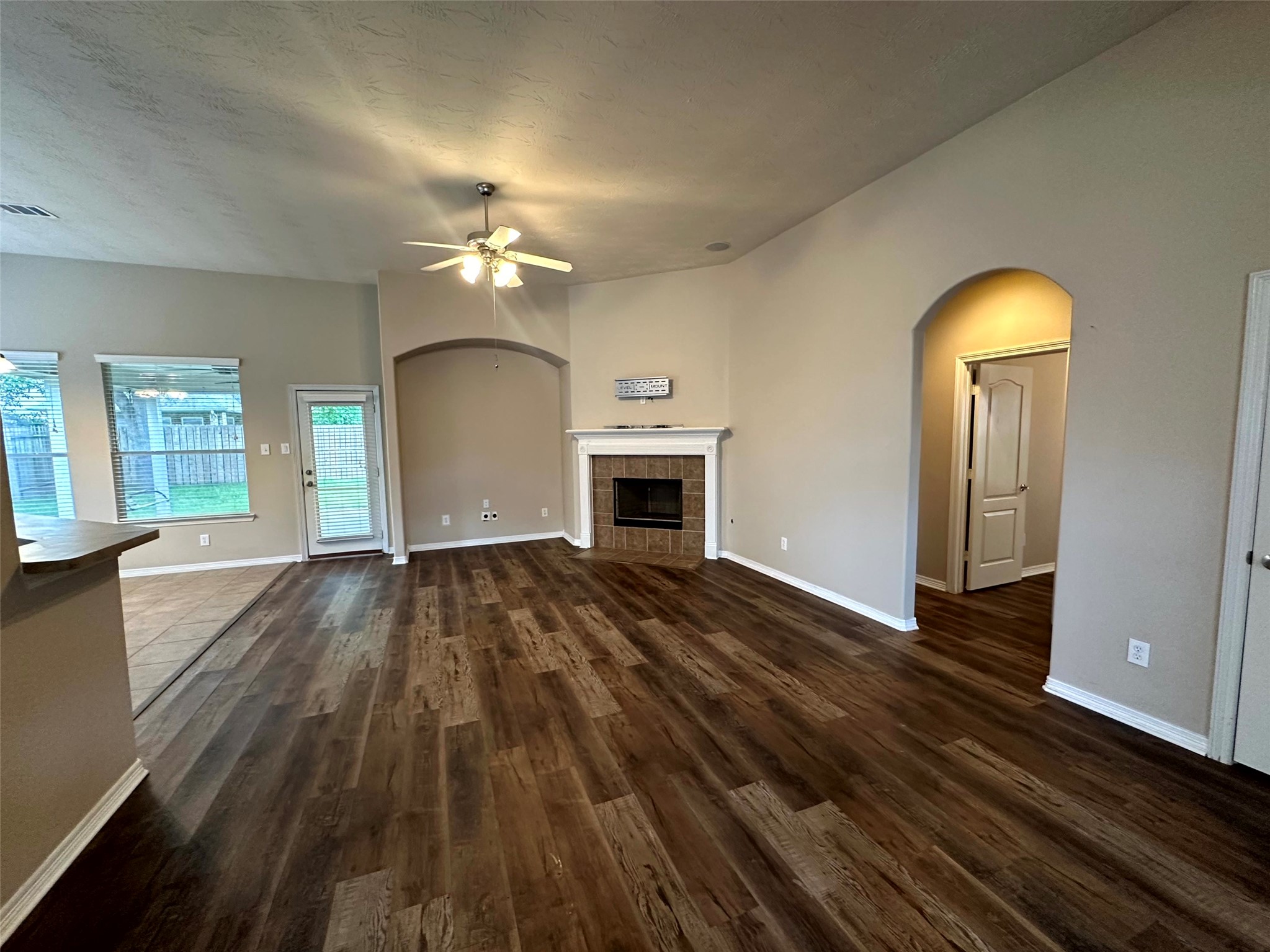 2047 Lulach Lane Conroe, TX 77301 - Photo 4 of 20 an empty room with wooden floor fireplace and windows