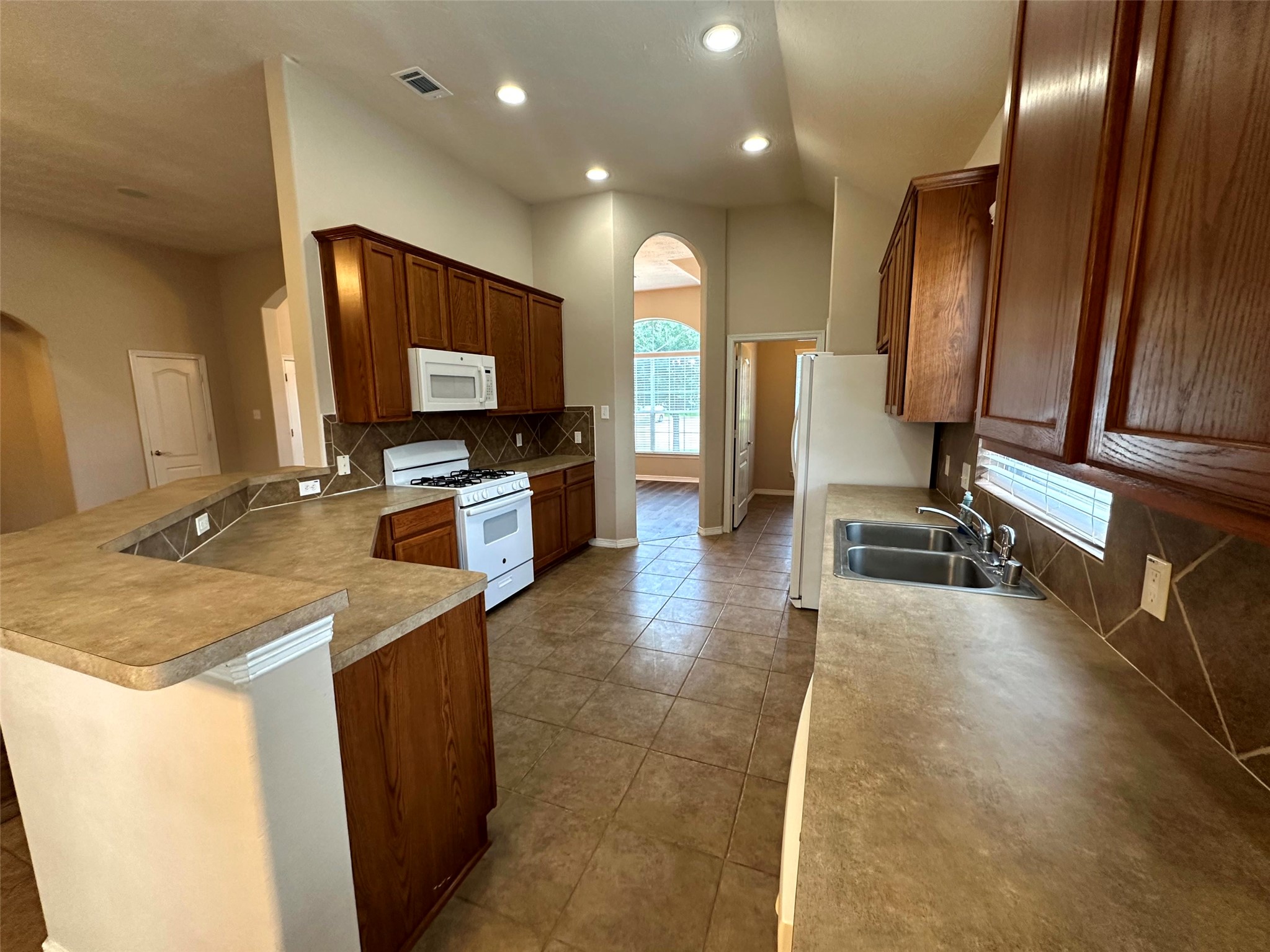 2047 Lulach Lane Conroe, TX 77301 - Photo 5 of 20 a view of a kitchen with kitchen island a sink wooden floor and a counter top space