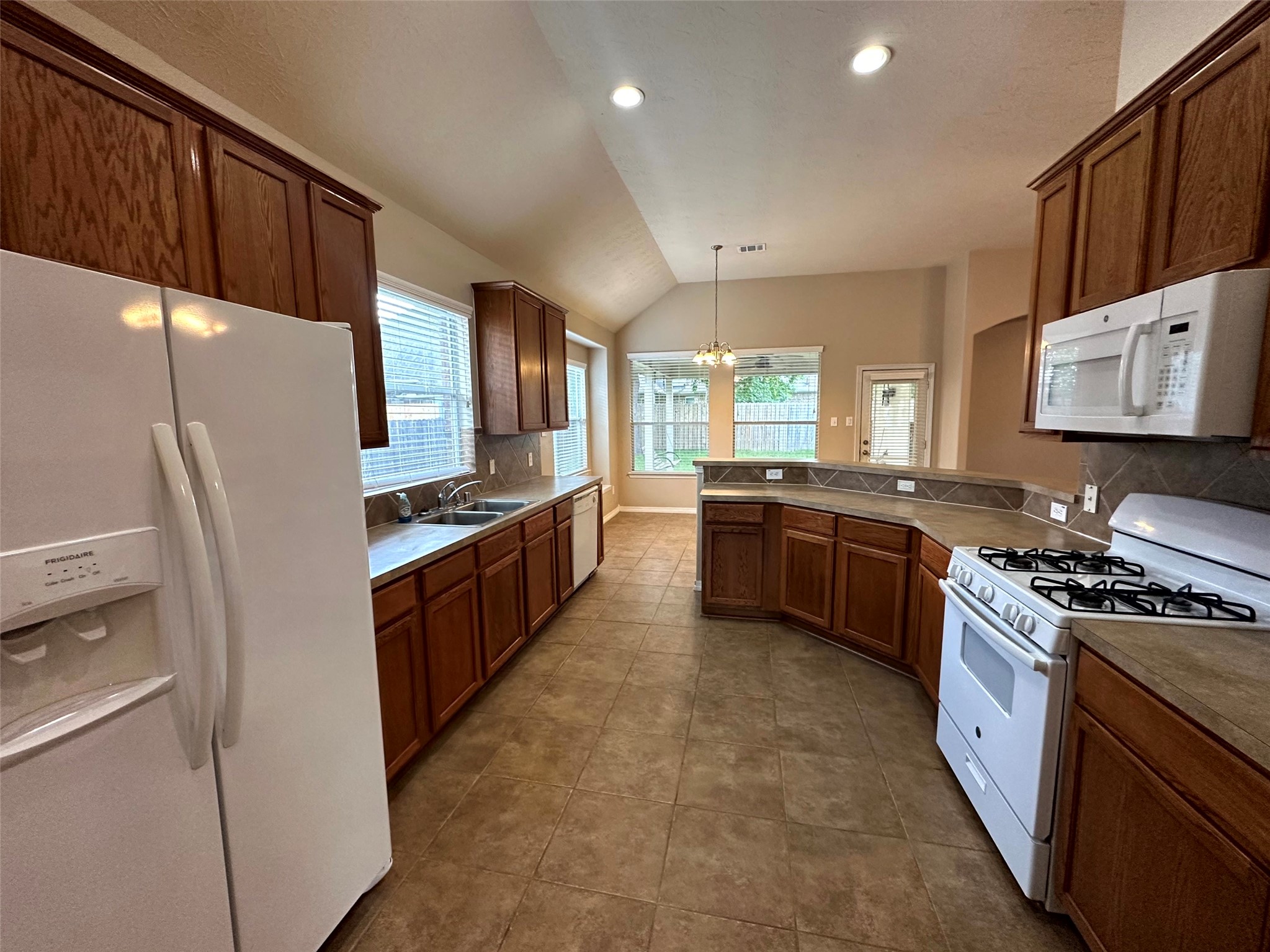 2047 Lulach Lane Conroe, TX 77301 - Photo 6 of 20 a large kitchen with stainless steel appliances kitchen island granite countertop a stove a sink dishwasher and a refrigerator